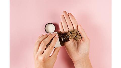 Tablets of dietary supplements in hand for daily pills intake on pink background. Set of zinc pills, antioxidants from aging, lecithin and adaptogen | Image Credit: Adobe Stock Images/Rabizo Anatolli